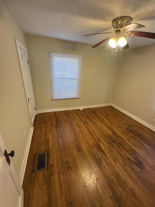 unfurnished room with dark hardwood / wood-style flooring, ceiling fan, and a textured ceiling