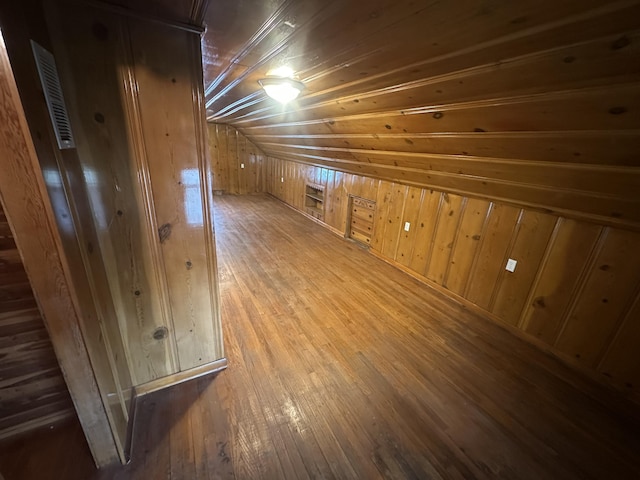 bonus room featuring wood ceiling, wooden walls, wood-type flooring, lofted ceiling, and visible vents