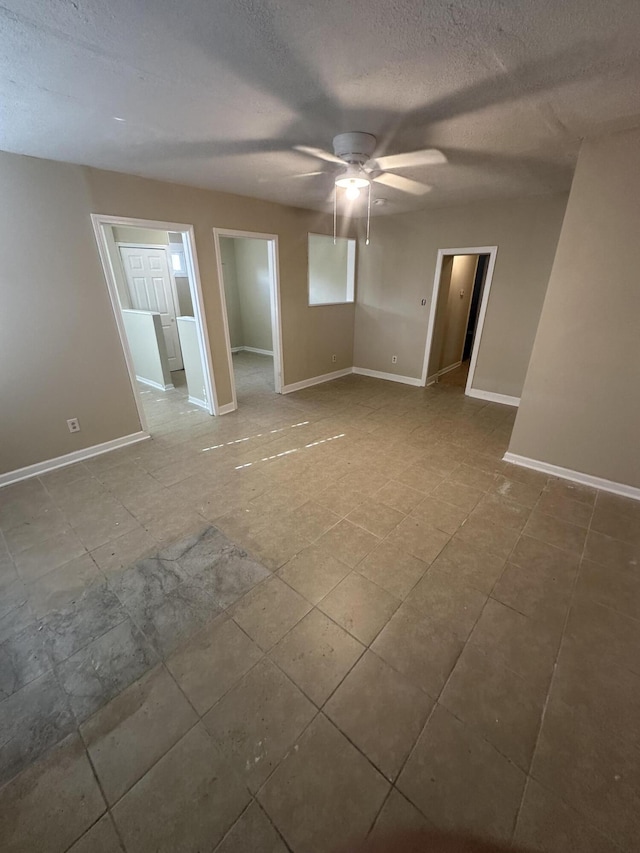 unfurnished room with ceiling fan and a textured ceiling