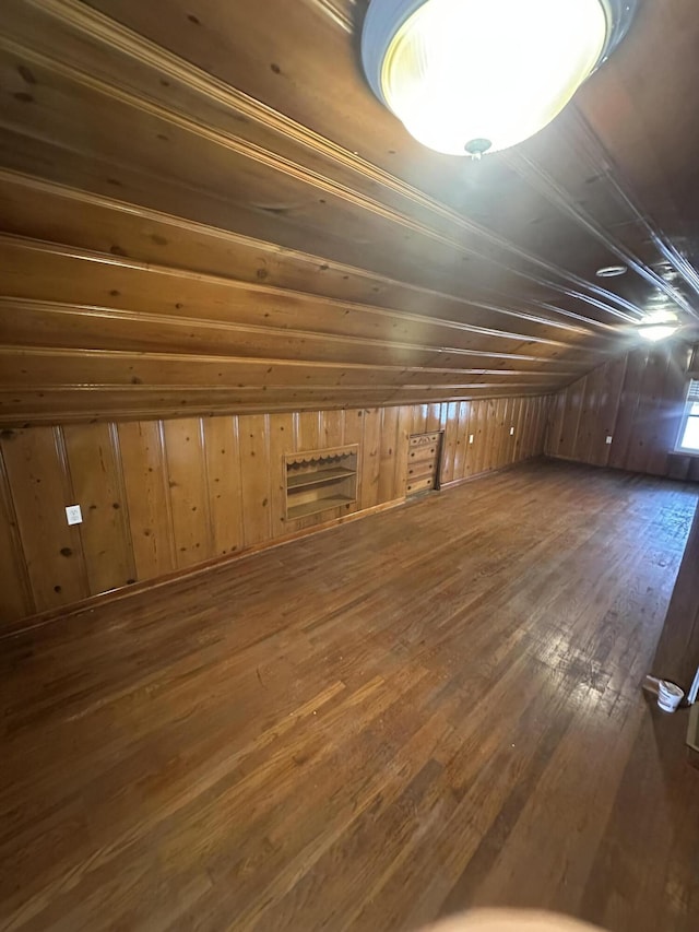 below grade area with hardwood / wood-style floors and wooden walls