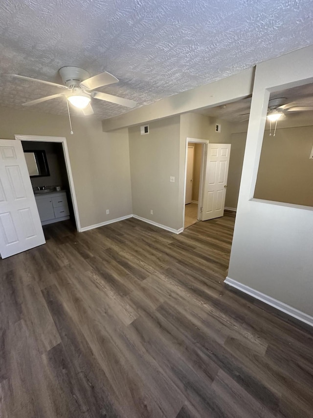 empty room with dark hardwood / wood-style floors, a textured ceiling, and ceiling fan