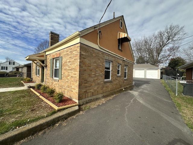 view of side of home featuring a garage and an outdoor structure