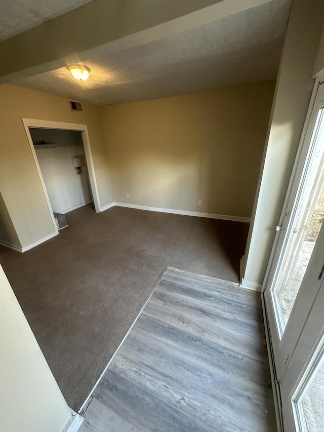 carpeted spare room with a textured ceiling