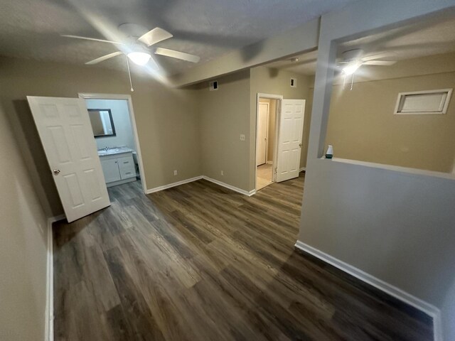 empty room featuring dark wood-style floors, baseboards, and ceiling fan