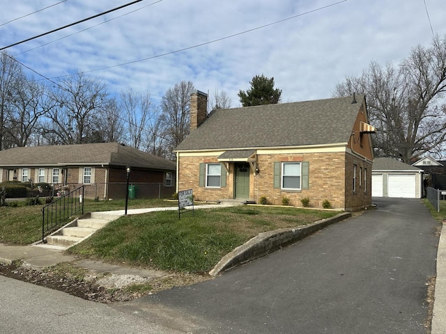 view of front facade featuring an outbuilding, a garage, and a front yard