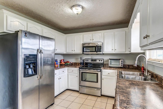 kitchen featuring white cabinetry, sink, stainless steel appliances, a textured ceiling, and light tile patterned flooring