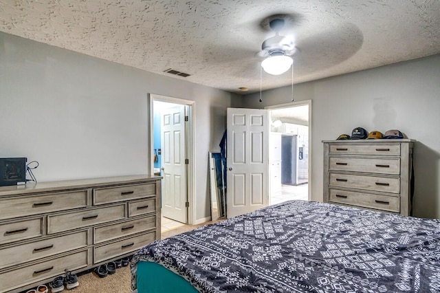 bedroom with ceiling fan and a textured ceiling