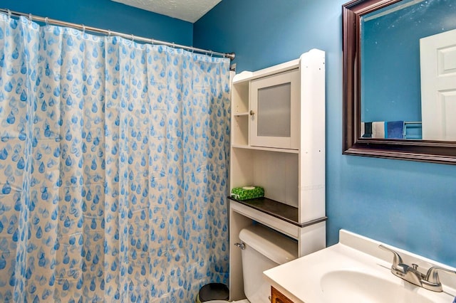 bathroom featuring vanity, a textured ceiling, toilet, and curtained shower