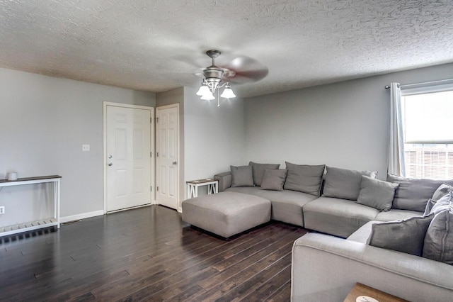 living room with dark hardwood / wood-style floors, ceiling fan, and a textured ceiling