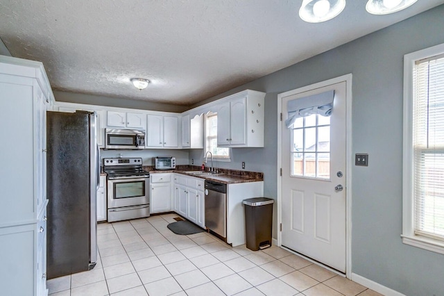 kitchen with white cabinets, stainless steel appliances, a wealth of natural light, and sink