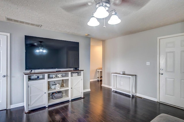 living room featuring a textured ceiling, ceiling fan, and dark wood-type flooring