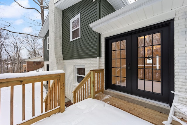 snow covered deck with french doors