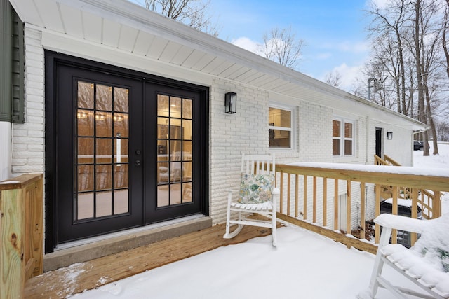 snow covered property entrance with french doors