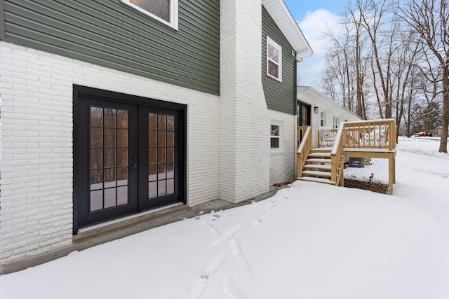 snow covered property featuring a wooden deck and french doors