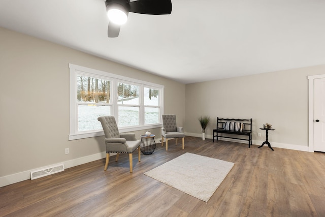 living area with hardwood / wood-style floors and ceiling fan