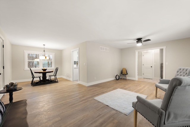 living room featuring ceiling fan and light hardwood / wood-style flooring