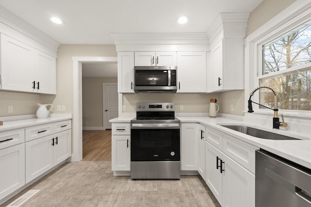 kitchen featuring white cabinetry, sink, light stone counters, and appliances with stainless steel finishes