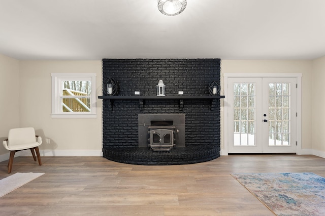 living room with hardwood / wood-style floors, french doors, and a wood stove