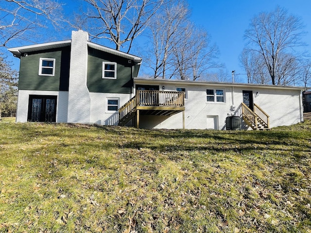 back of house featuring a deck, a lawn, and central air condition unit