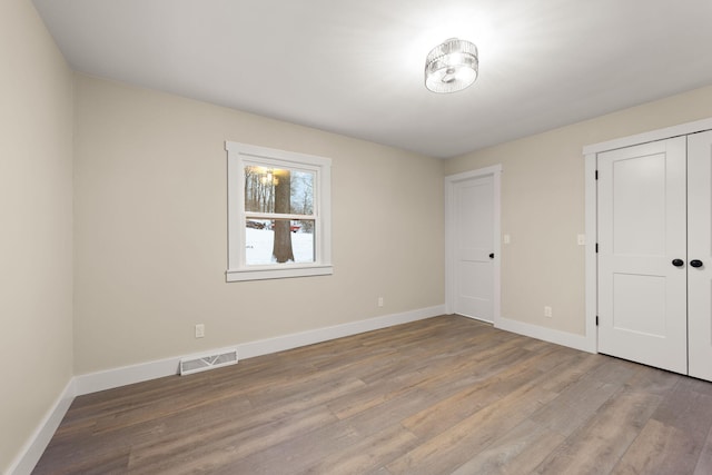 unfurnished bedroom featuring hardwood / wood-style floors and a closet