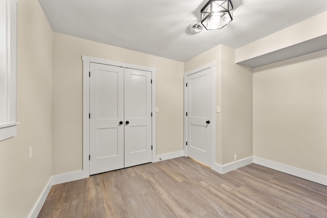 unfurnished bedroom with light wood-type flooring and a closet