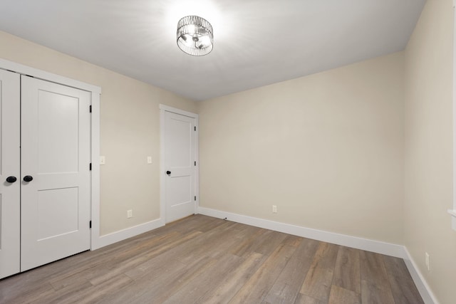 unfurnished bedroom featuring light hardwood / wood-style floors and a closet