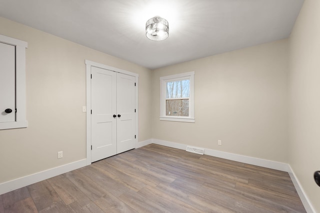 unfurnished bedroom featuring a closet and light wood-type flooring