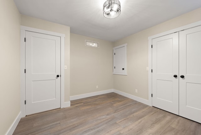 unfurnished bedroom with light hardwood / wood-style flooring and a closet