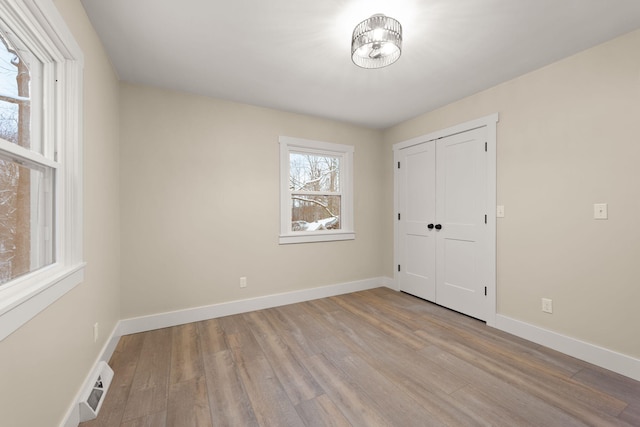 unfurnished bedroom with a closet and light wood-type flooring