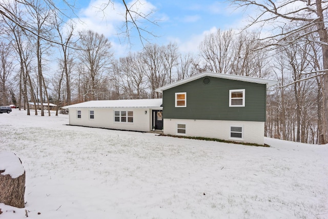 view of snow covered back of property