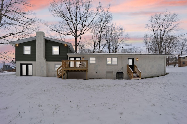 snow covered property featuring central AC and a deck