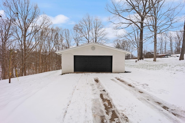 snow covered structure featuring a garage