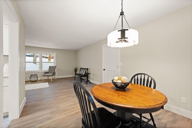 dining space with a chandelier and light wood-type flooring