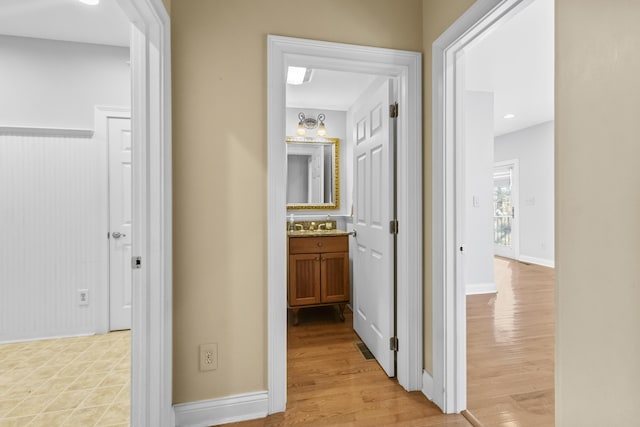 hallway with light hardwood / wood-style floors