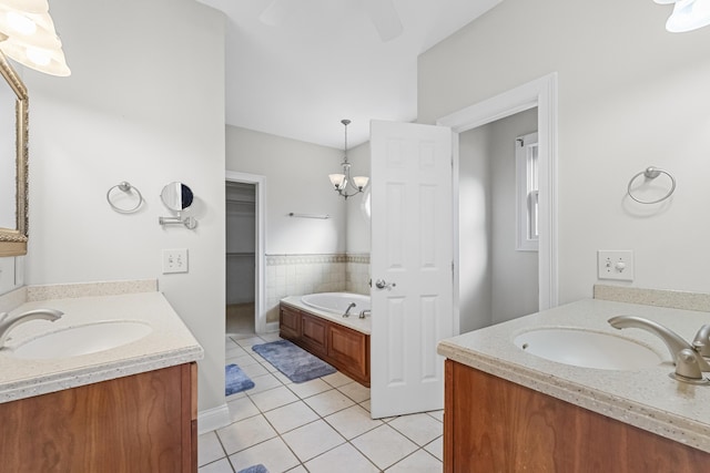 bathroom featuring tile patterned floors, vanity, a bathtub, and an inviting chandelier