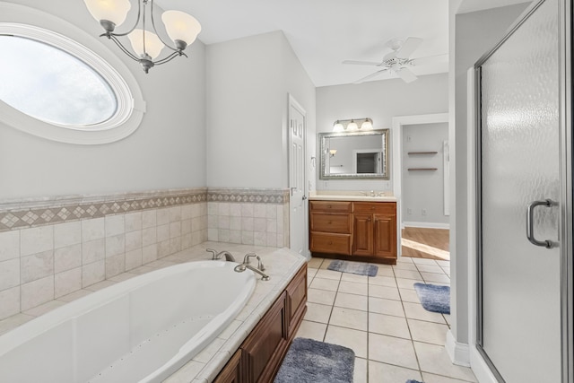 bathroom with tile patterned flooring, shower with separate bathtub, vanity, and ceiling fan with notable chandelier