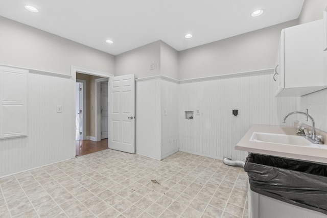 laundry room with wood walls and sink