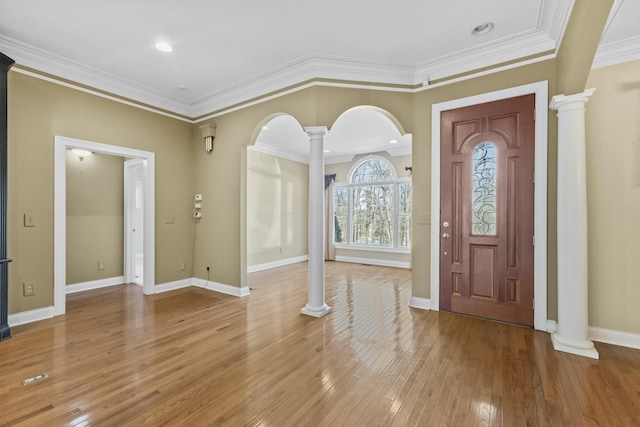 entryway featuring hardwood / wood-style floors, ornate columns, and ornamental molding