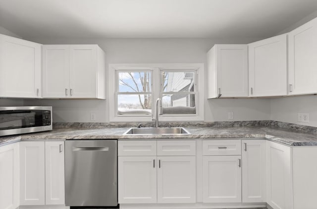 kitchen with stainless steel appliances, sink, and white cabinets