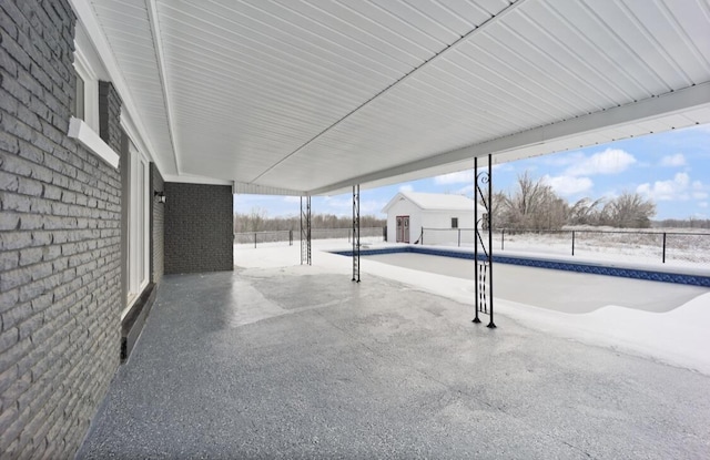 snow covered patio featuring an empty pool