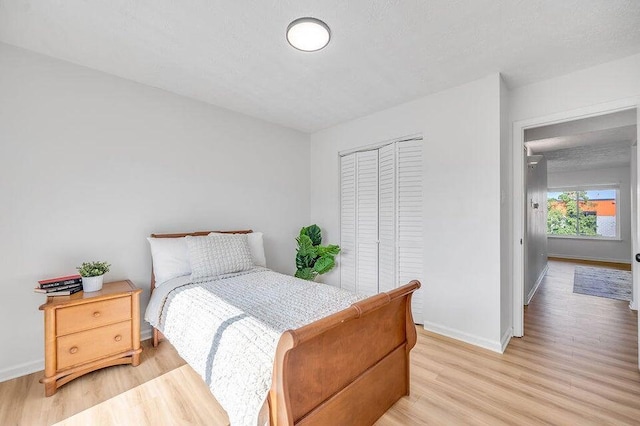 bedroom with light hardwood / wood-style floors and a closet