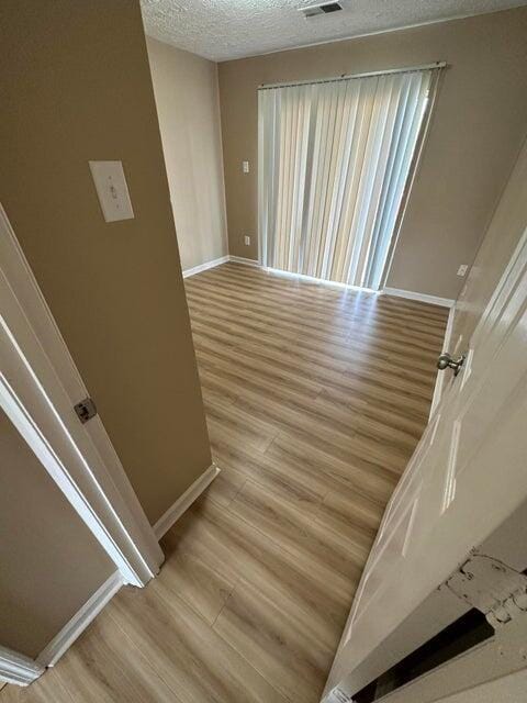 interior space with light hardwood / wood-style flooring and a textured ceiling