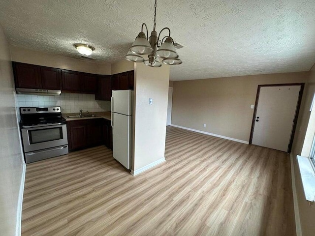 kitchen with white refrigerator, decorative light fixtures, stainless steel electric range oven, tasteful backsplash, and a notable chandelier