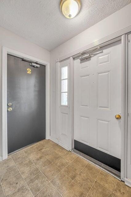 foyer entrance with a textured ceiling