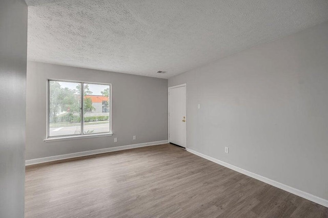 empty room featuring hardwood / wood-style floors and a textured ceiling