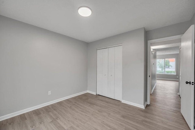 unfurnished bedroom featuring light hardwood / wood-style floors and a closet