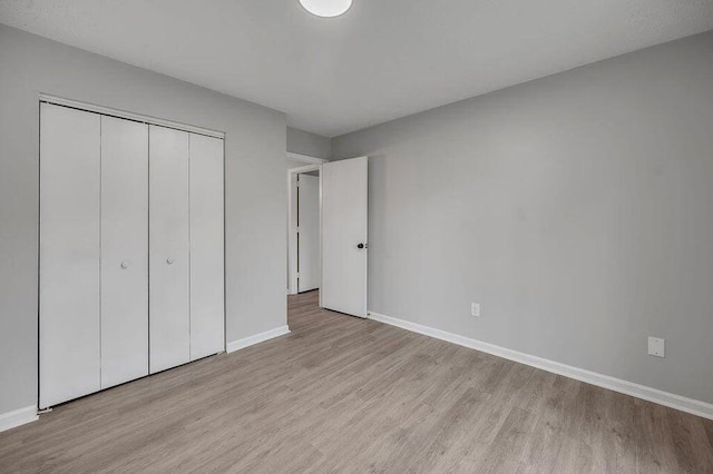 unfurnished bedroom featuring a closet and light hardwood / wood-style flooring