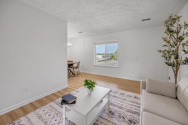 living room featuring light hardwood / wood-style flooring and a textured ceiling