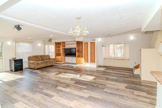 living room with a chandelier, hardwood / wood-style floors, and beamed ceiling