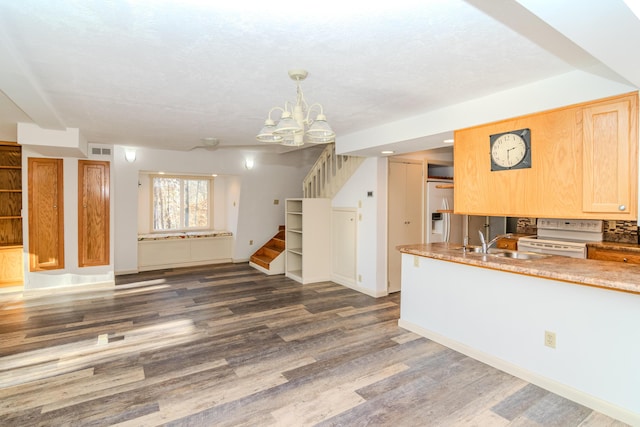 kitchen with dark hardwood / wood-style flooring, light brown cabinetry, electric stove, hanging light fixtures, and sink